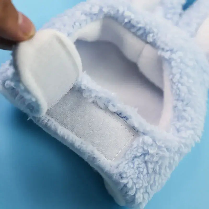Personne plaçant une serviette blanche sur une surface bleue avec un bonnet de lapin doux et mignon en vue