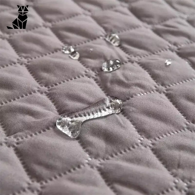 Gros plan sur une machine à piquer qui fabrique une couverture de lit imperméable pour chien de [Nom de la marque]